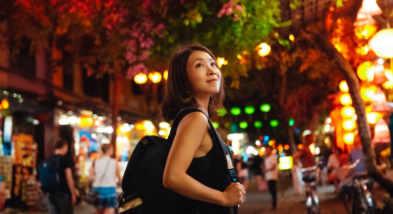 Young female traveller exploring local market at night in Vietnam during Chinese New Year. Solo traveller. Travel like a local.
1450014803
Young Asian woman with a backpack walking through a night market in Vietnam