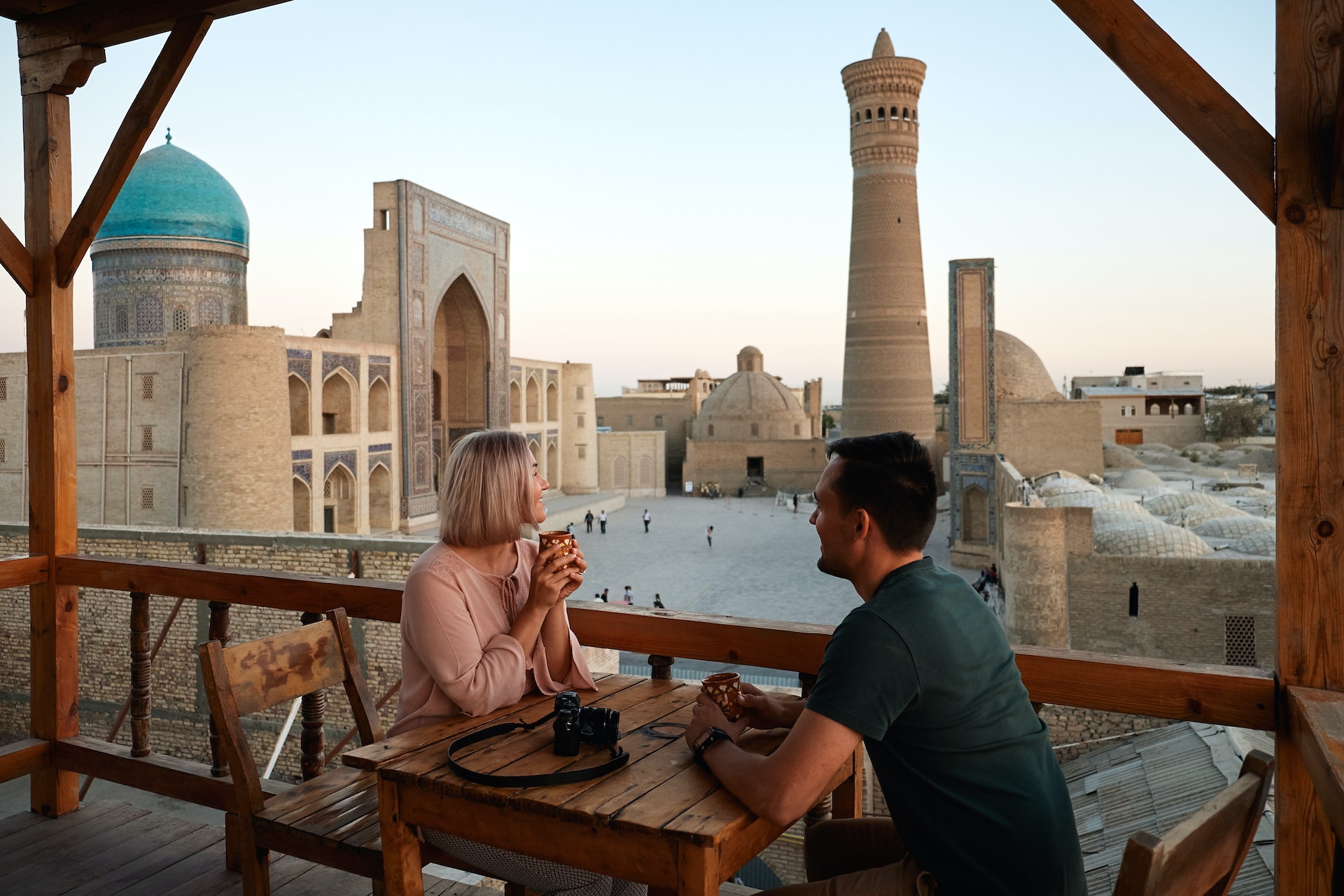Two tourists sitting having tea at East Islam City Center Square in Uzbekistan 