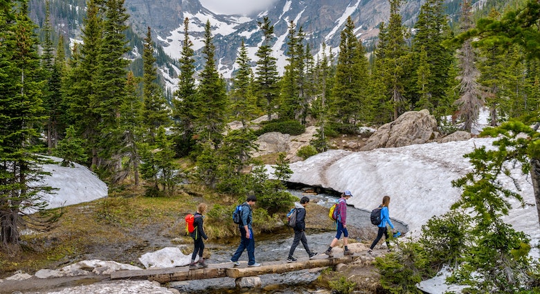 Estes Park, Colorado, USA - June 24, 2017: On a foggy spring day, a group of hikers walking cross a tree trunk bridge over Tyndall Creek on Emerald Lake Trail at base of Hallett Peak and Flattop Mtn.
708951949